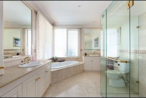 a bathroom with a tub and a toilet and a sink at Luxurious Townhouse Retreat in Prestigious Brighton in Melbourne