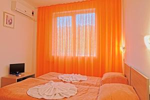 an orange room with a bed and a window at Sunset Complex in Kosharitsa +31 photos