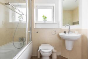 a bathroom with a toilet and a sink and a shower at Modern 2 Bed Apartment London Lewisham - Perfect for Long Stays in London
