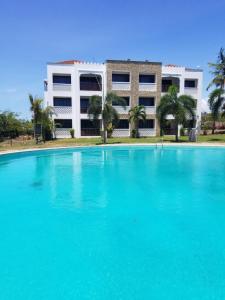 a large swimming pool in front of a building at Almasi beach house in Mtwapa