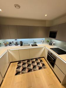 cocina con armarios blancos y alfombra de cocina en Two bedroom apartment with 2 bathroom, en Londres