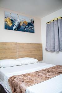 a bedroom with two beds and a painting on the wall at Hotel Grand Horizon Rodadero in Santa Marta