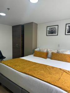 a bedroom with a large bed in a room at Hotel WLH Gold Bogota in Bogotá