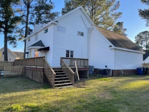 a large white barn with a wooden fence in front of it at Beautiful Home located in an Amazing Neighborhood! in Winterville