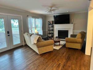 a living room with two chairs and a fireplace at Beautiful Home located in an Amazing Neighborhood! in Winterville