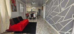 a living room with a red couch and a kitchen at Posada Hill View in Providencia