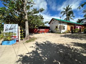 una strada con un albero e un edificio di In Dai Aquasports and Beach Resort a Isola di Bantayan