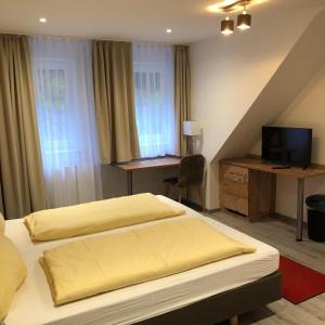 una camera con 2 letti e una scrivania con TV di Gasthaus Hotel Löffelschmiede a Hinterzarten