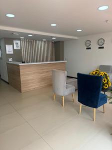 a waiting room with two chairs and a counter at Hotel WLH Gold Bogota in Bogotá