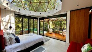 a bedroom with a bed and a large glass window at Macas Glamping in Macas +48 photos