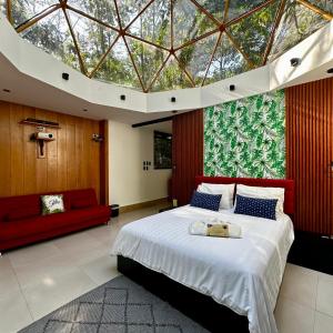 1 dormitorio con 1 cama grande y techo de cristal grande en Macas Glamping, en Macas