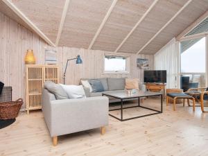 a living room with a couch and a table at Four-Bedroom Holiday home in Rønde 1 in Rønde