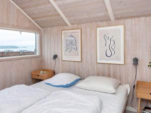 a bedroom with a bed and two lamps and a window at Four-Bedroom Holiday home in Rønde 1 in Rønde
