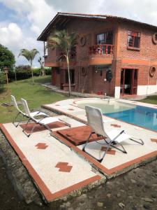 una casa con 2 sillas y una piscina en Villa Ines, en Playa Verde