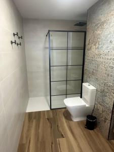 a bathroom with a toilet and a glass shower at Beach Apartments Valencia in Valencia