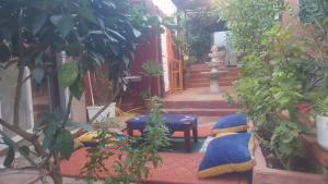un giardino con sedie blu e una statua sullo sfondo di DAR LAMRABET a Bine el Ouidane