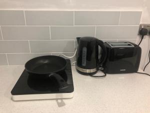 a kitchen counter with a coffee pot and a toaster at studio flat near NEC, Solihull & Airport. Short & Long stay Contractors HS2, NHS in Solihull