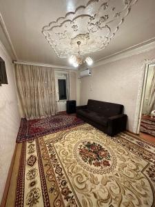 uma sala de estar com um sofá e um lustre em Samir Gues Hause em Ganja