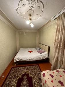 um pequeno quarto com uma cama e um lustre em Samir Gues Hause em Ganja
