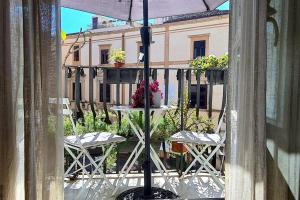 uma varanda com cadeiras e uma mesa com vasos de plantas em Casa Rivoluzione (da Elvira) em Palermo