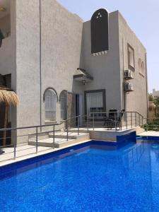 a house with a swimming pool in front of a building at La villa H in Houmt Souk
