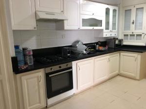 a kitchen with white cabinets and a black counter top at La villa H in Houmt Souk