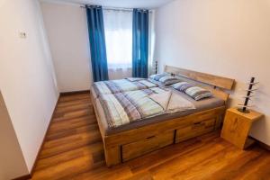 1 dormitorio con cama de madera y cortinas azules en Ferienwohnung Widdern, en Möckmühl