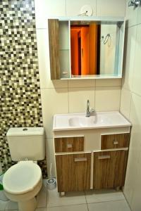 グラマドにあるResidencial Encantos da Naturezaのトイレ、洗面台、鏡のあるバスルーム +15枚の写真
