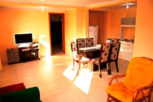 グラマドにあるResidencial Encantos da Naturezaのテーブルと椅子、キッチンのあるリビングルーム