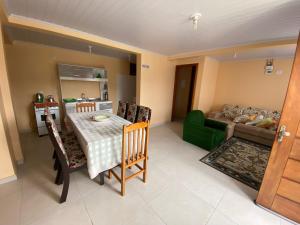 グラマドにあるResidencial Encantos da Naturezaのリビングルーム(テーブル、緑のソファ付)