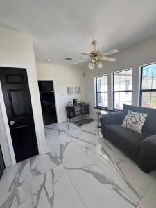 a living room with a couch on a marble floor at Home lux in Louisiana in Laplace