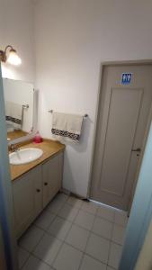 ein Bad mit einem Waschbecken und eine Tür mit einem Spiegel in der Unterkunft Hostal El Encuentro in Mendoza