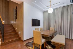 ein Esszimmer mit einem Tisch, Stühlen und einer Treppe in der Unterkunft Luxurious Six Bedroom Apartment in Lekki
