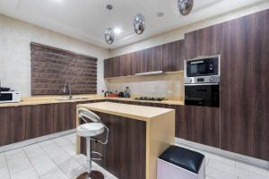 eine Küche mit Holzschränken, einer Spüle und einem Herd in der Unterkunft Luxurious Six Bedroom Apartment in Lekki