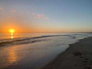 - un coucher de soleil sur une plage donnant sur l'océan dans l'établissement 690A Pukehina - Whare Iti, à Pukehina