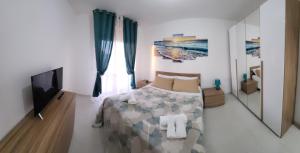 a bedroom with a bed and a flat screen tv at Il bacio del sole in Campomarino