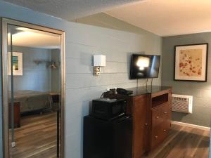 a room with a room with a bed and a television at Lamplighter Motel in Longmont