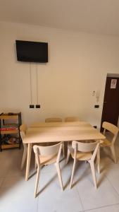 a wooden table and chairs in a room with a tv at Le mie stelle 1 in La Spezia