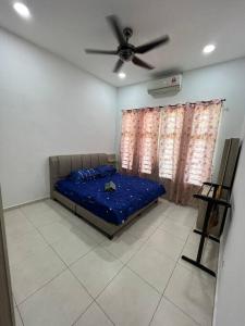 een bed in een kamer met een plafondventilator bij Villa D' Manggis Melaka in Melaka