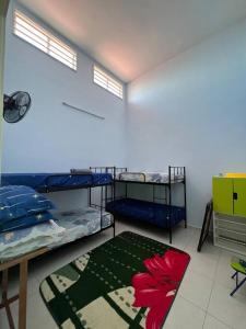 een kamer met 3 stapelbedden en een tapijt bij Villa D' Manggis Melaka in Melaka