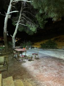 a picnic table and chairs in a park at night at ain alsett house in Kerak