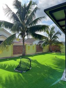 een golfhoepel in een tuin met een palmboom bij Villa D' Manggis Melaka in Melaka
