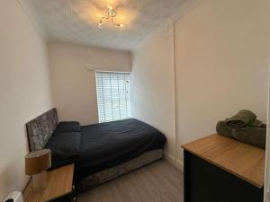 a small bedroom with a bed and a window at Modern & Stylish 1 bedroom flat in Bridgend town in Bridgend