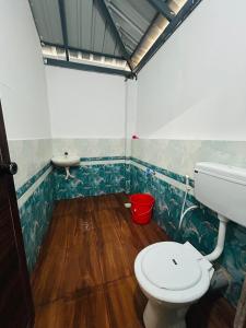 a bathroom with a toilet and a sink at Athirappilly Inn in Athirappilly