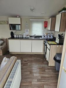 a kitchen with white cabinets and a counter top at Pack and go holidays in Ingoldmells