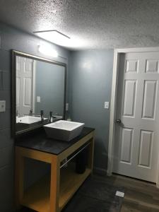 a bathroom with a sink and a mirror at Lamplighter Motel in Longmont