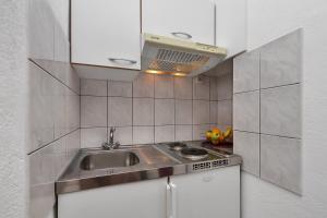 a small kitchen with a sink and a microwave at Apartments by the sea Igrane, Makarska - 20373 in Igrane +31 photos