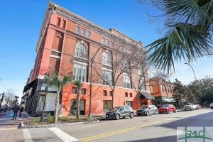 un bâtiment en briques rouges avec des voitures garées devant lui dans l'établissement Charming Savannah Penthouse: Grand Views & Dual Parking, à Savannah