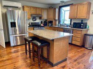 a kitchen with a refrigerator and a counter with stools at Avenue of the Giants River View Home (#1) 