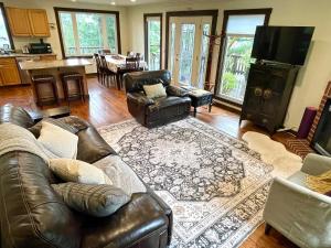 a living room with a leather couch and chairs at Avenue of the Giants River View Home (#1) in Miranda